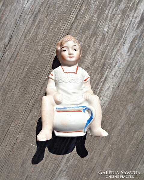 Régi biszkvit porcelán bilin ülő fiú persely figura