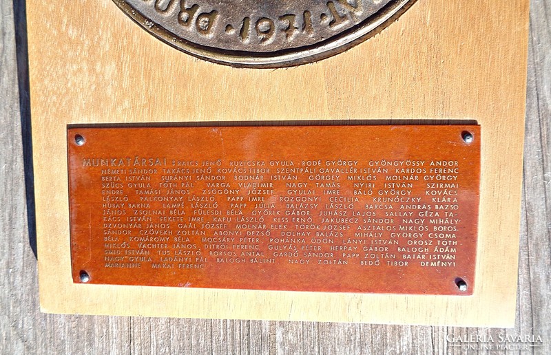 Larger bronze plaque on a wooden base