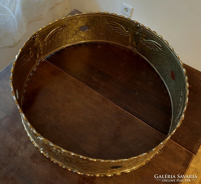 A large art deco chandelier with an ornate polished copper center ring