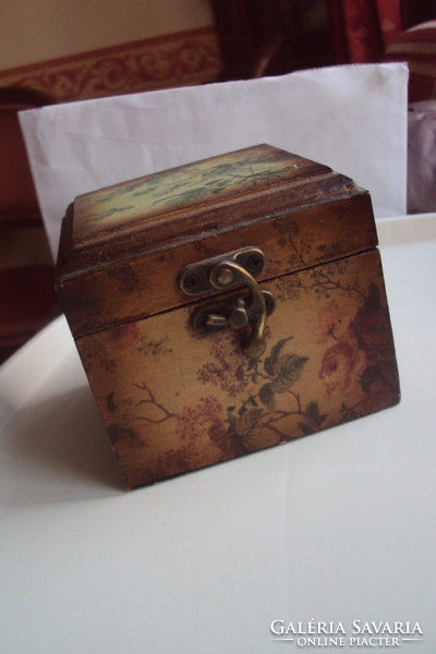 Small vintage wooden jewelry box in the style of a pirate chest, brown velvet lining, aged lock.