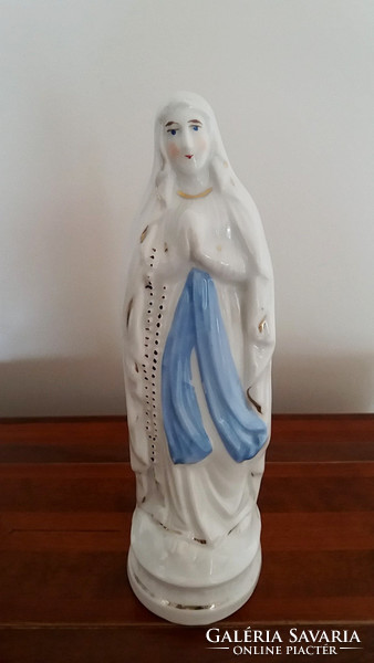 Old religious porcelain statue of Mary with relics