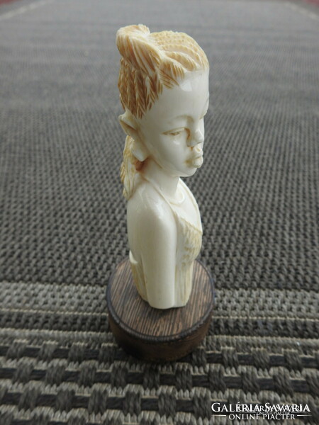 Antique oriental bone sculpture on wooden pedestal
