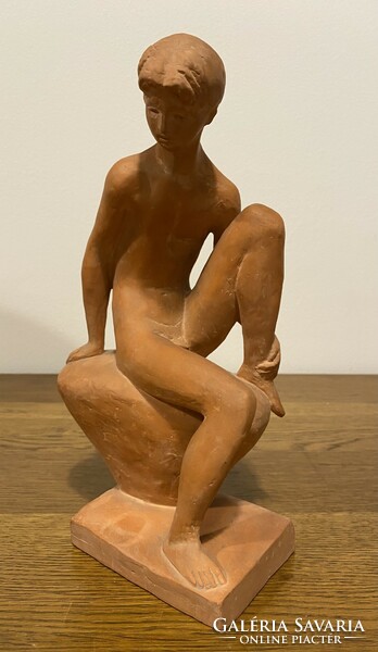 Nude terracotta statue of a boy sitting on a marble stone from Lesenye