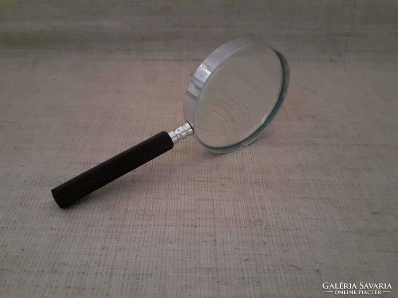 Large magnifying glass with old metal housing and screw handle