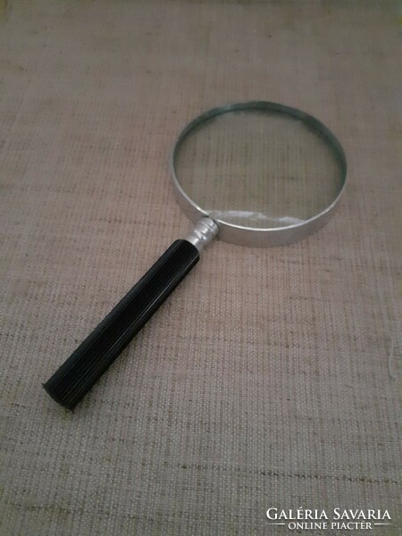 Large magnifying glass with old metal housing and screw handle