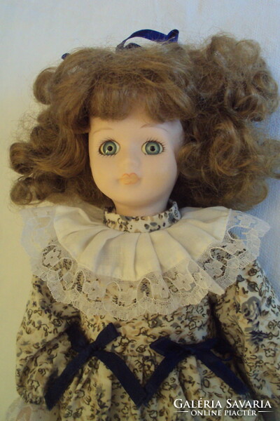 Antique fairy doll, with porcelain head and limbs, in a vintage-style lace, ruffled dress.