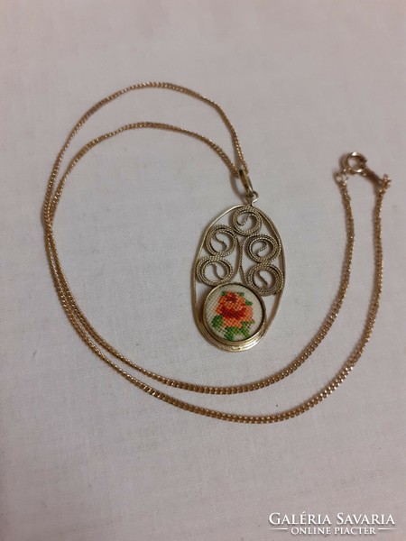 A filigree pendant on a chain adorned with tapestry in a beautiful retro condition