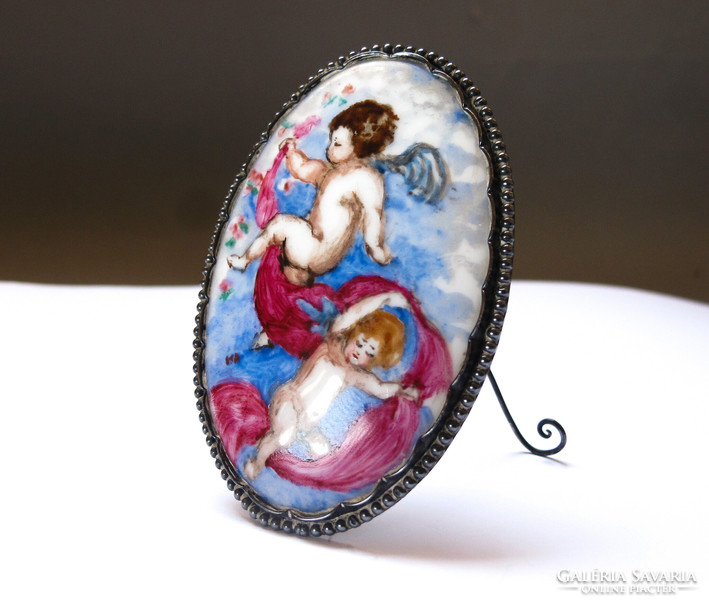 Old, putto, painted porcelain table decoration in a silver frame.