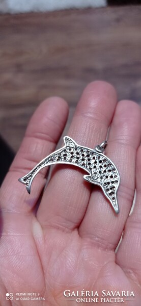 Silver dolphin pendant with lots of stones.