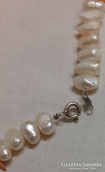 Beautiful condition real pearl necklace with coral eyes in the middle with a silver clasp.