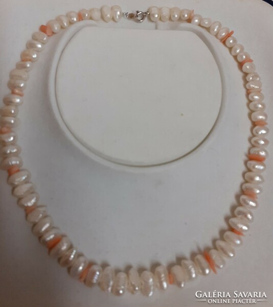 Beautiful condition real pearl necklace with coral eyes in the middle with a silver clasp.