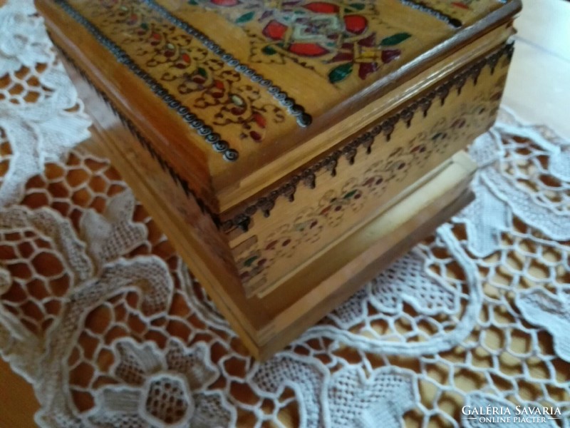 Retro carved and painted wooden box offering cigarettes.