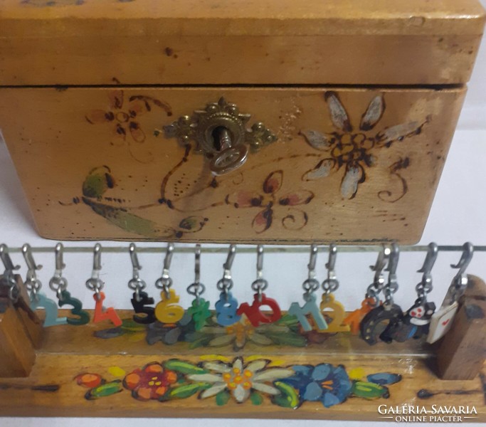 An old hand-painted small box of old mountain hay with a matching powder indicator holder with hook numbers