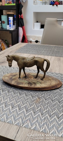 Antique bronze horse statue on a wooden base.