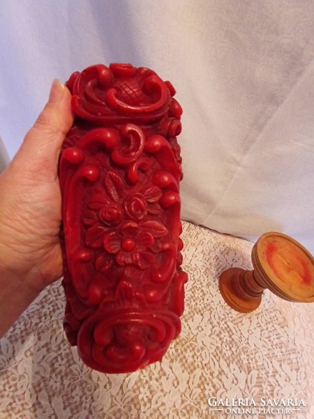 A large block of candles with a carved effect with a wooden candle holder