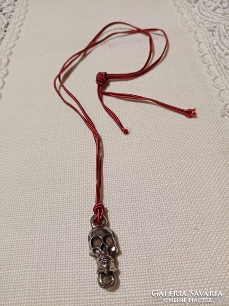 Silver-plated gilded skull pendant on a burgundy cord