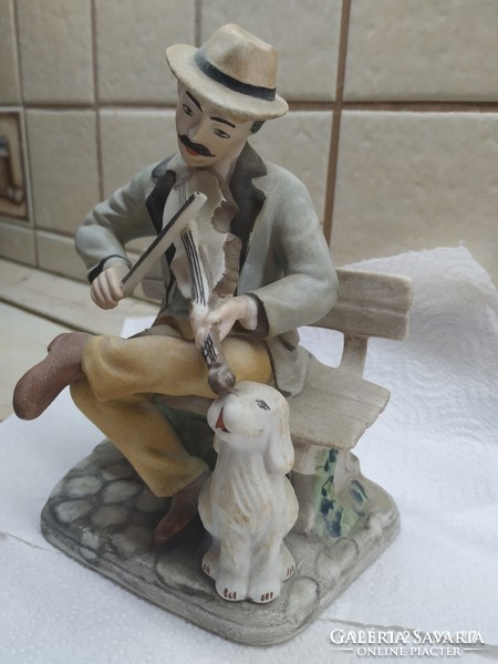 Street musician with dog, figurative porcelain for sale! A man sitting on a bench playing the violin with a dog