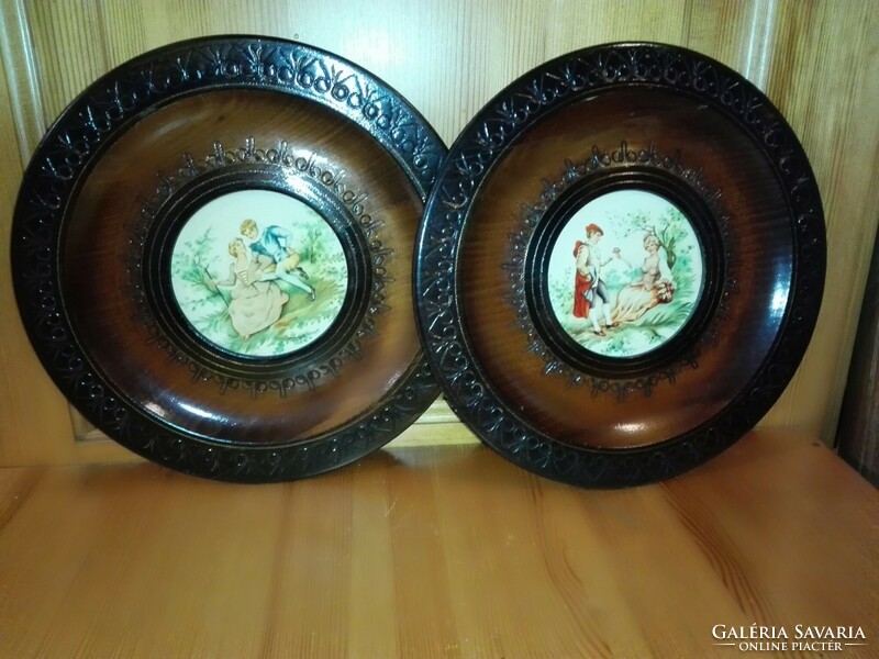 Old decorative plate on the wall, in the middle of a carved tree, with a contemporary image.