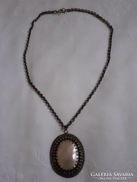 A beautiful silver-plated necklace with a large mother-of-pearl pendant
