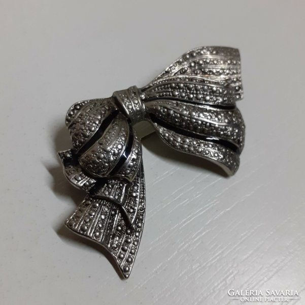 A silver-colored bow-shaped brooch in nice condition