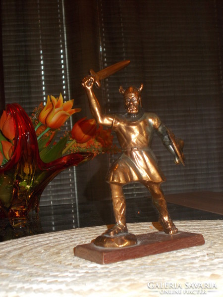 Old solid bronzed copper statue on a pedestal with a battle scene