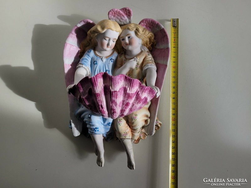 Old biscuit porcelain angels holding a large wall holy water container