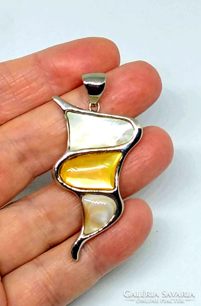 A mother-of-pearl pendant with shell inlay