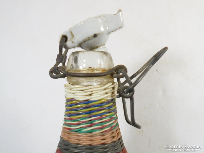 A small glass bottle with a retro wire braided demizon-like buckle