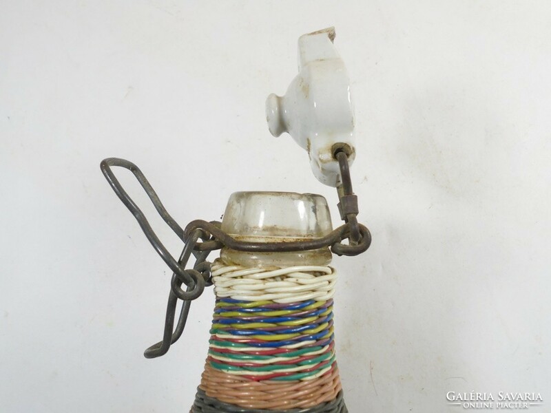 A small glass bottle with a retro wire braided demizon-like buckle