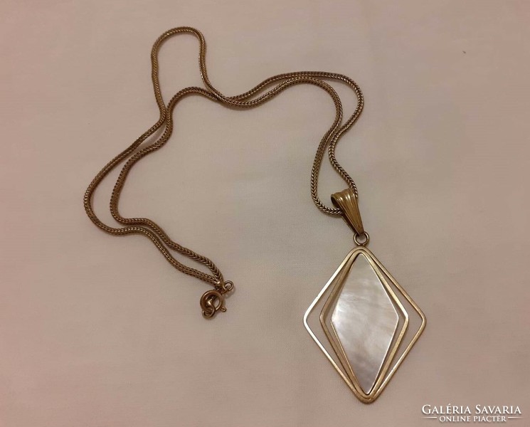 A beautiful copper-colored (or similar) necklace with a mother-of-pearl pendant