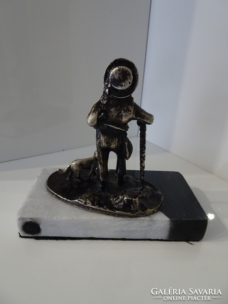 Antique statue of a boy walking with his dog on a marble foot.