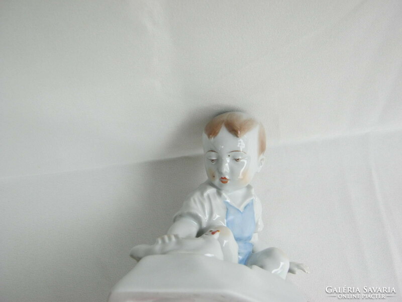 Little boy stroking Zsolnay porcelain hen