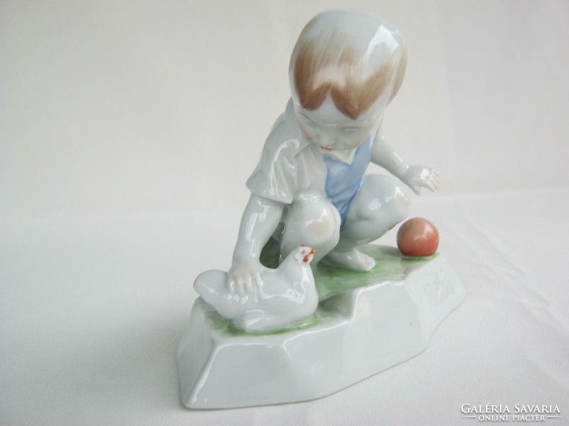 Little boy stroking Zsolnay porcelain hen