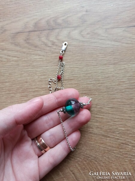 Silver necklace decorated with colored glass.