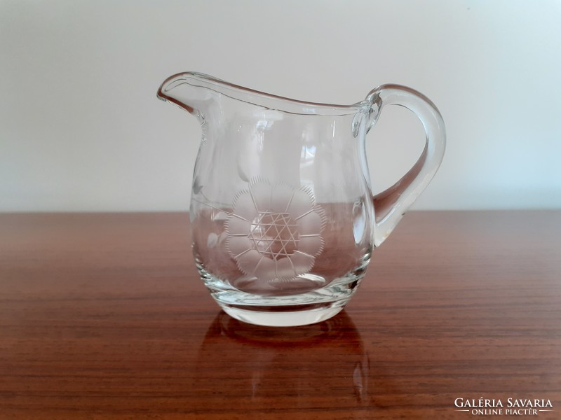 Old small jug pouring lemon juice into glass