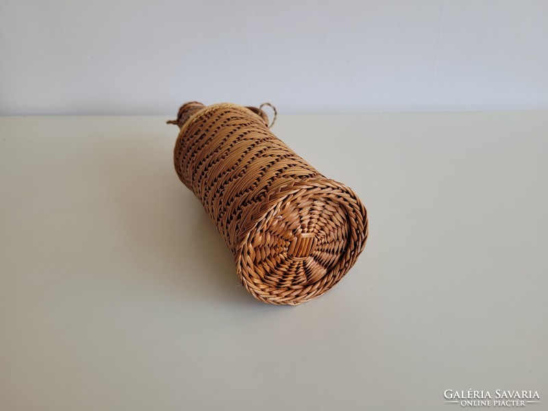 Old retro woven 1 l glass bottle with wine brandy in a small demizon