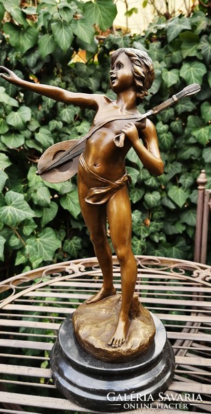 Boy playing music - bronze statue