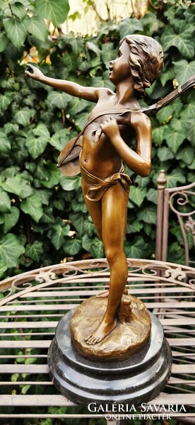 Boy playing music - bronze statue