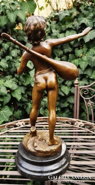 Boy playing music - bronze statue