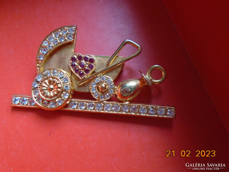 Gold-plated pram brooch with many red and clear cut stones