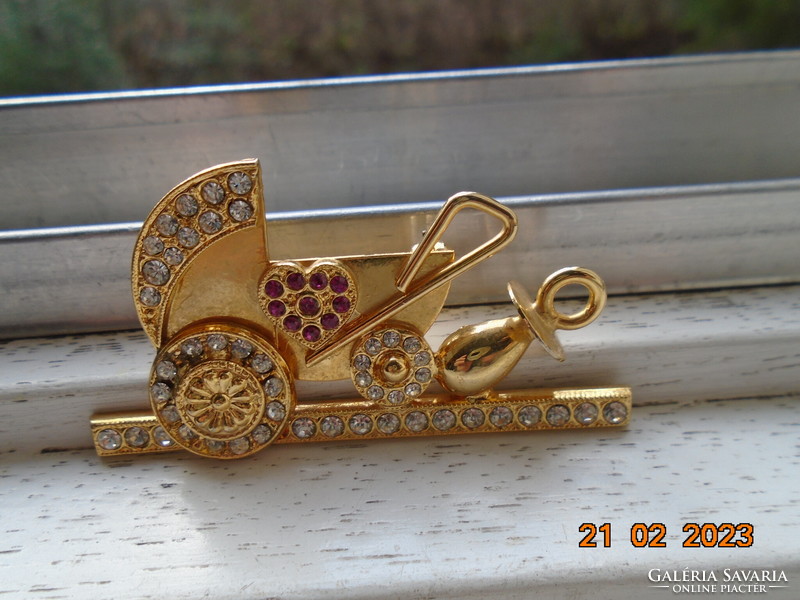 Gold-plated pram brooch with many red and clear cut stones