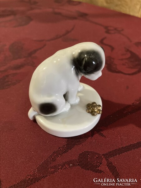 Miniature porcelain figure of a dog looking at a flower