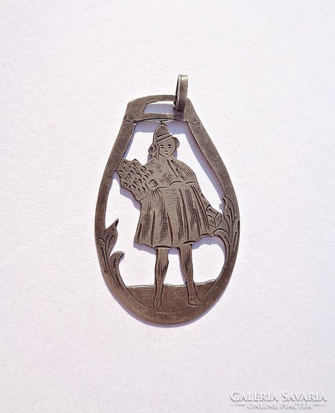 Old silver pendant, girl with a bouquet of flowers and a suitcase