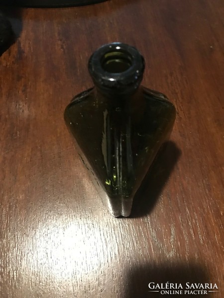 Old ant bitter glass bottle. It is green in color. Triangular shape. 18X10 cm undamaged.