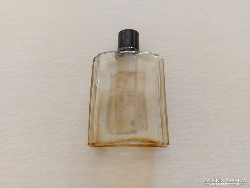 Old labeled perfume bottle with red carnation in vintage cologne bottle