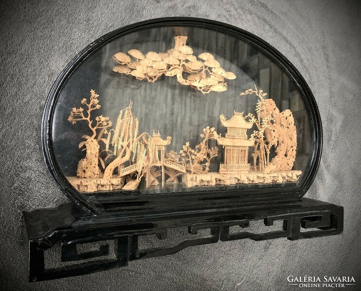 Old oriental carving in a wooden-glass display case.