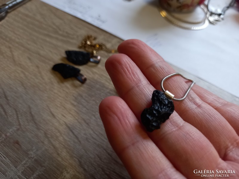 A piece of raw tektite meteorite on a silver clasp and silver chain