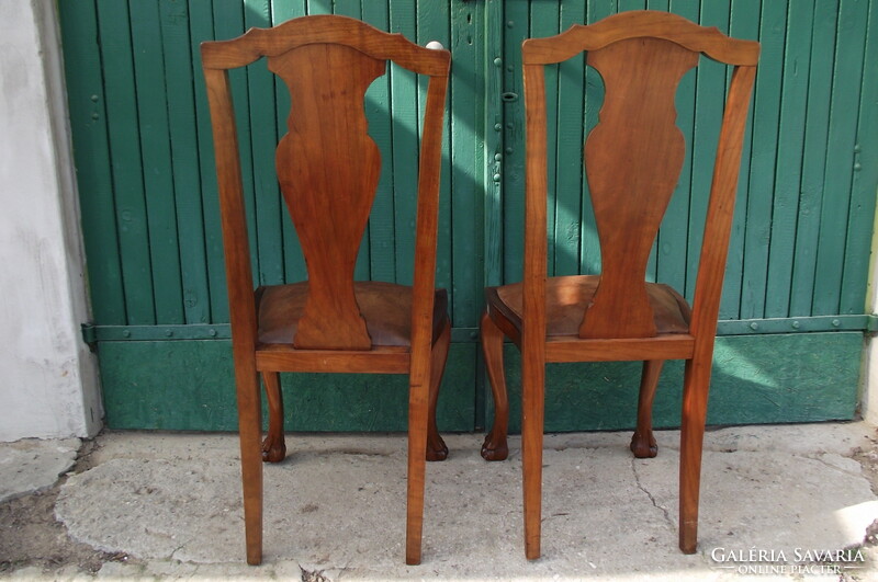 A pair of chairs with root veneer and leather seats.