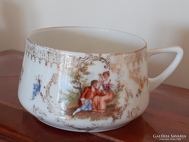 Old porcelain cup with Art Nouveau scene with gilded floral