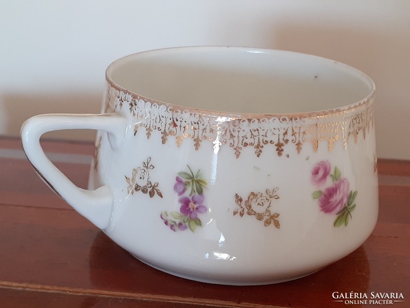 Old porcelain cup with Art Nouveau scene with gilded floral
